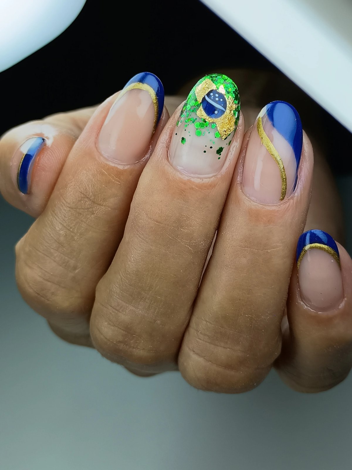 Alongamento de unhas com nail art da bandeira do Brasil em dourado